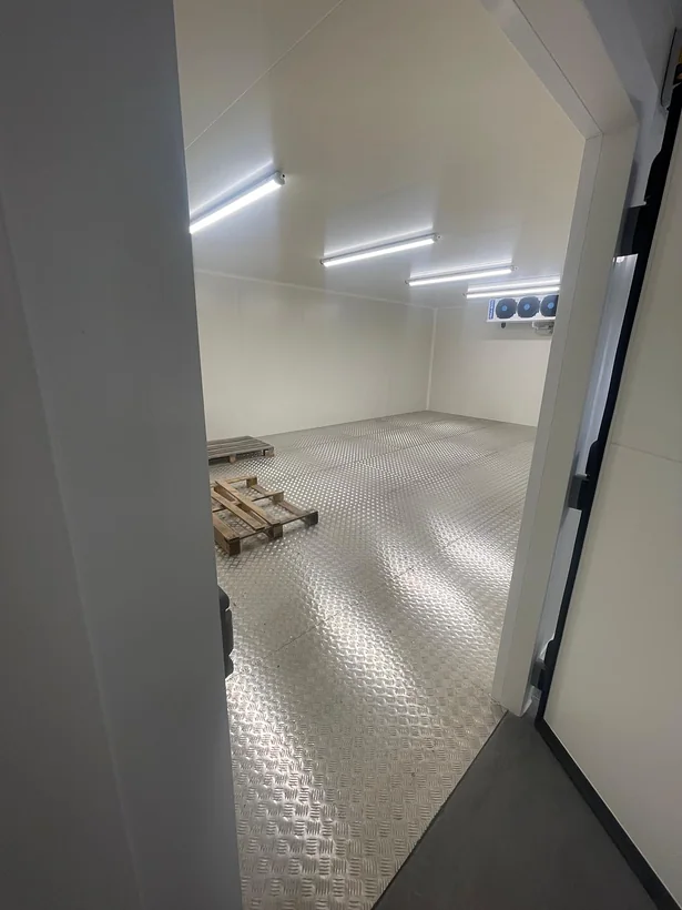 Chambre froide négative vue depuis la porte : parois et plafond en panneaux isothermes, sol en aluminium larmé