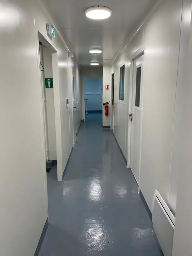 Couloir des laboratoires : cloisons en panneaux, portes à oculus, châssis vitrés
