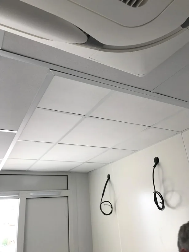 Détail du faux-plafond : dalles et ossature, cassette de climatisation