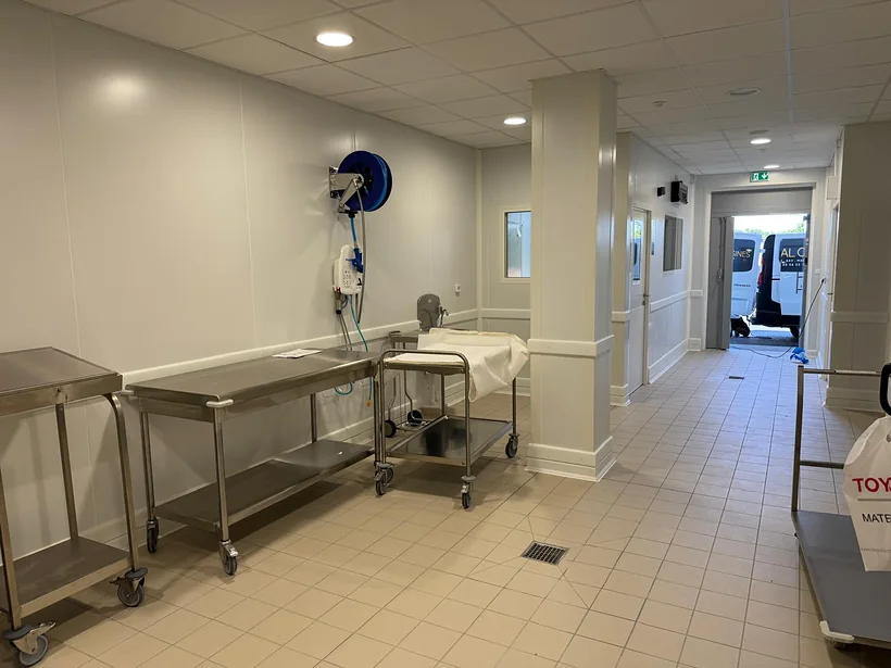 Zone de livraison : parois et poteau habillés en panneaux, lisses de protection, châssis vitrés